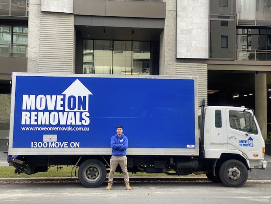 Move On Removals crew member with the company truck outside a Melbourne apartment building