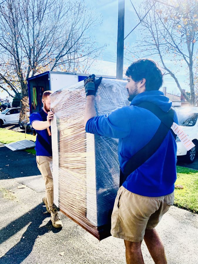 Move On Removals crew carefully carrying wrapped furniture during a house move