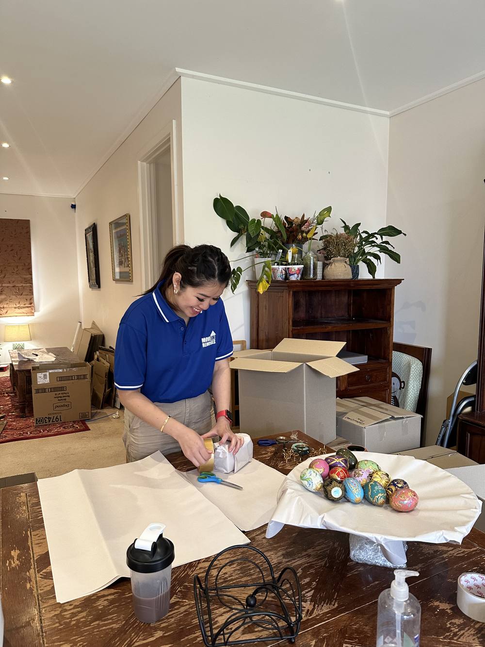 Move On Removals team member taping a box and wrapping fragile items