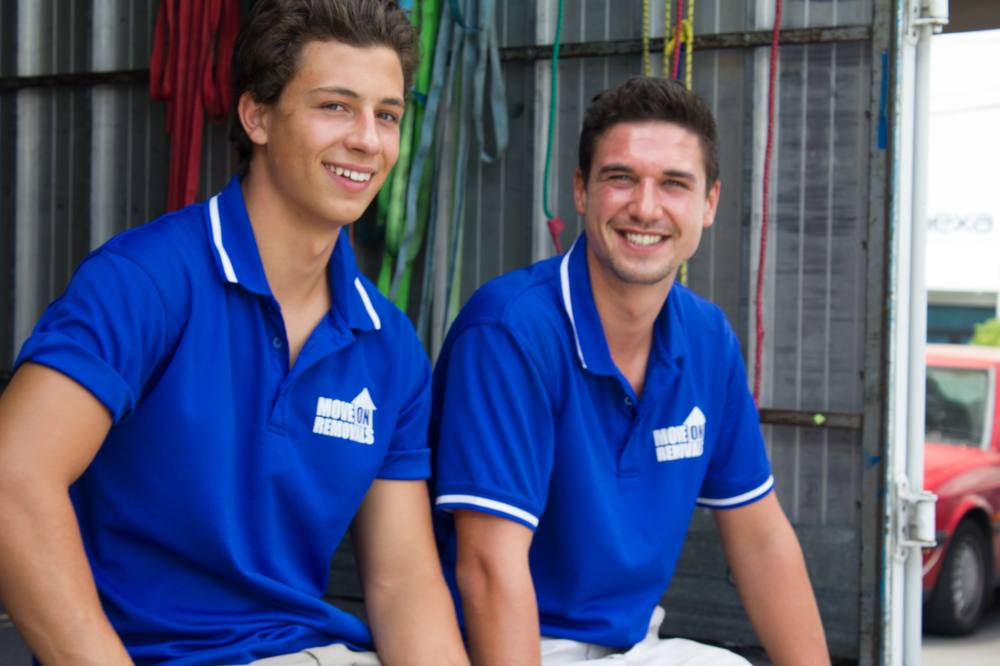 Two Move On Removals crew members smiling by the truck
