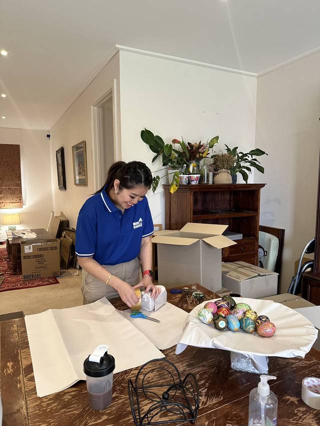 Move On Removals team member taping a box and wrapping fragile items