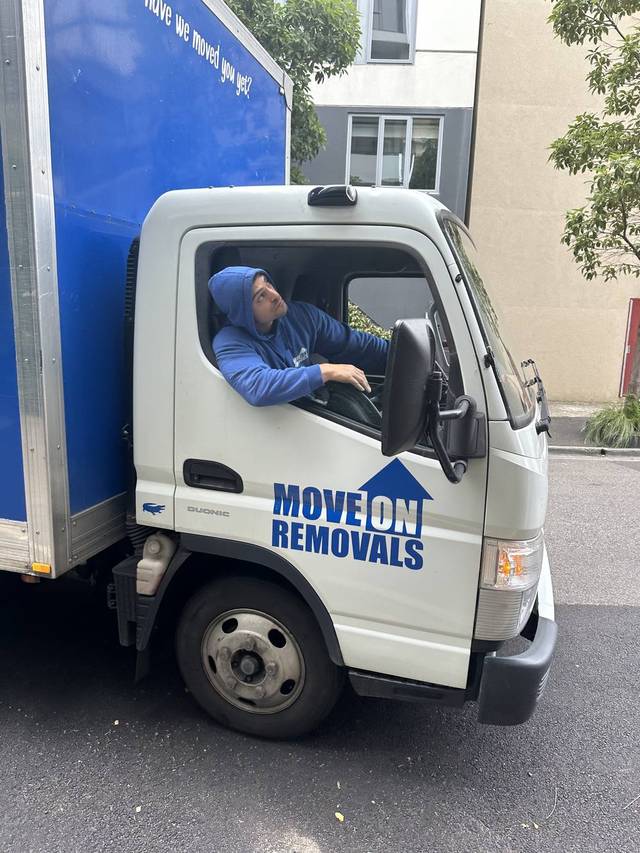 Move On Removals branded truck, crew member at the wheel